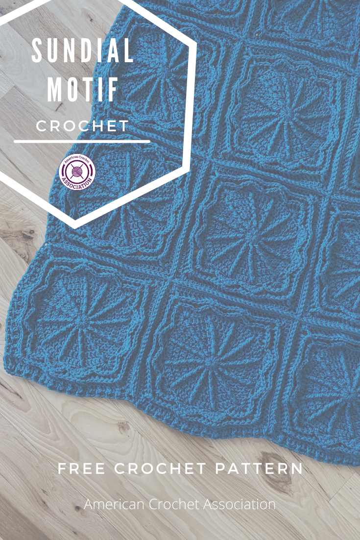 corner of blue crochet blanket laying flat on wooden floor