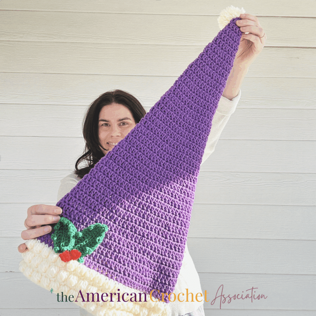 woman holding 25" long Santa Hat - Crochet Pattern - Salena Baca Crochet - American Crochet Association